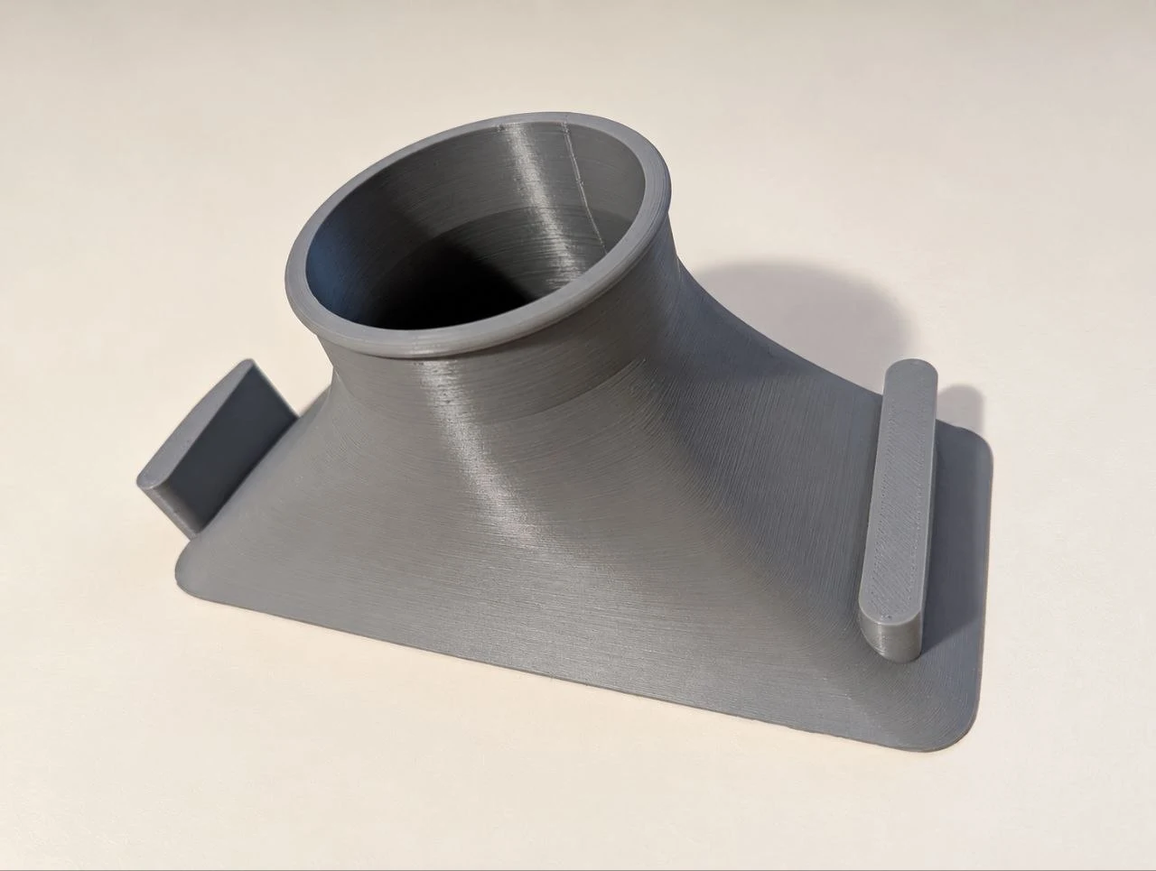 Grey 3D-printed BMW duct with a round opening, flared base and two mounting tabs