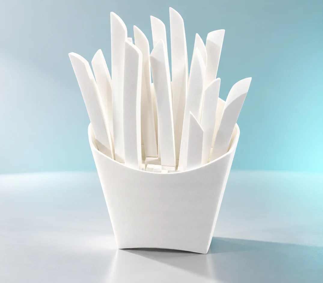 White EPS foam fries prop in a matching carton, with tall shaped fries against a pale blue background